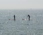 Pratique du paddle, un sport nautique qui se pratique debout sur une planche longue et large